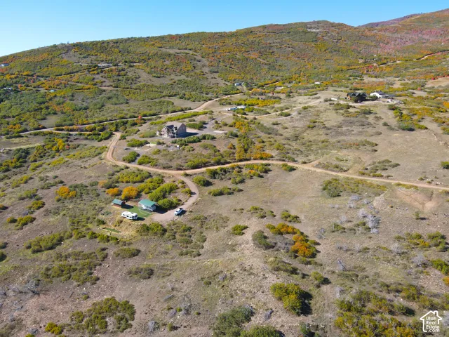 Expansive mountain terrain with winding unpaved roads and multiple structures