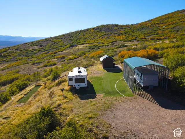 Property featuring a storage shed, a covered structure, and expansive natural terrain
