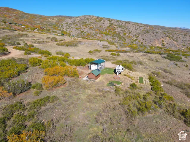 Hillside property featuring a rustic cabin and a covered structure