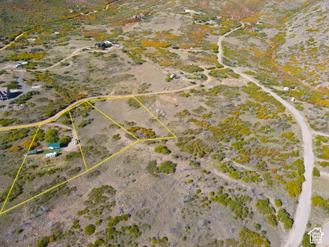 Expansive land featuring a dirt road, varied vegetation, and multiple marked property boundaries