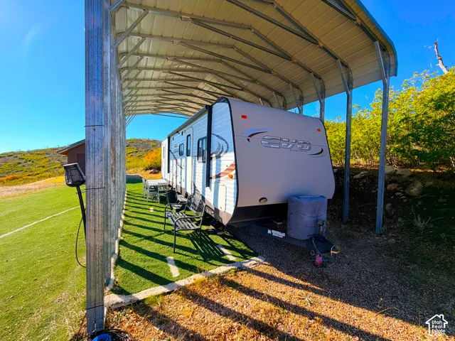 Covered RV carport with a gravel base and artificial turf pad