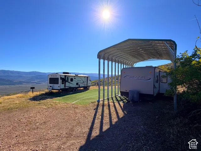 Metal carport structure over gravel pad