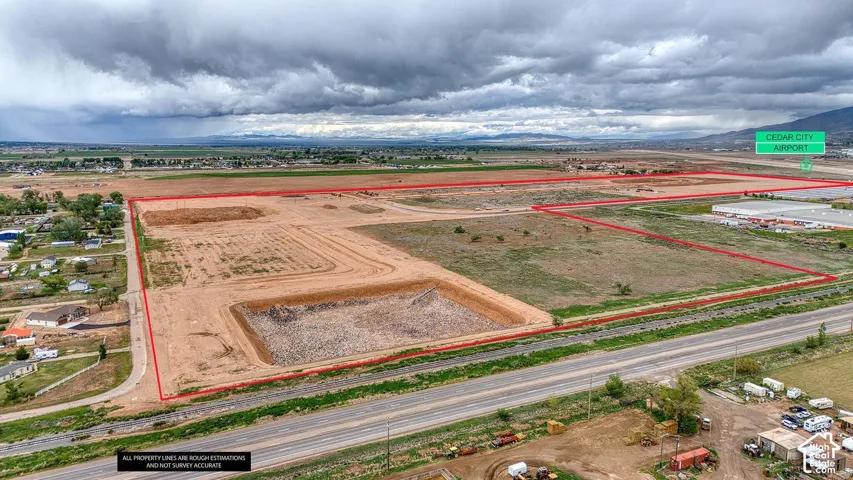 Expansive undeveloped land featuring a cleared section, natural ground cover, and adjacent roadway access