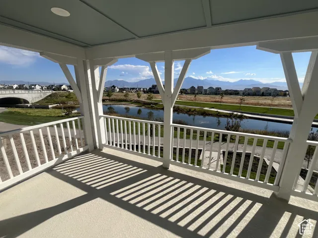 Covered outdoor balcony with a white railing and textured flooring