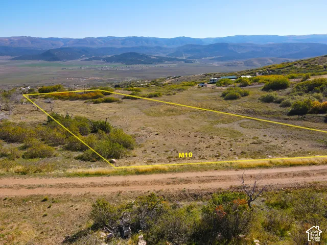 Expansive land parcel featuring natural vegetation and distant mountain ranges