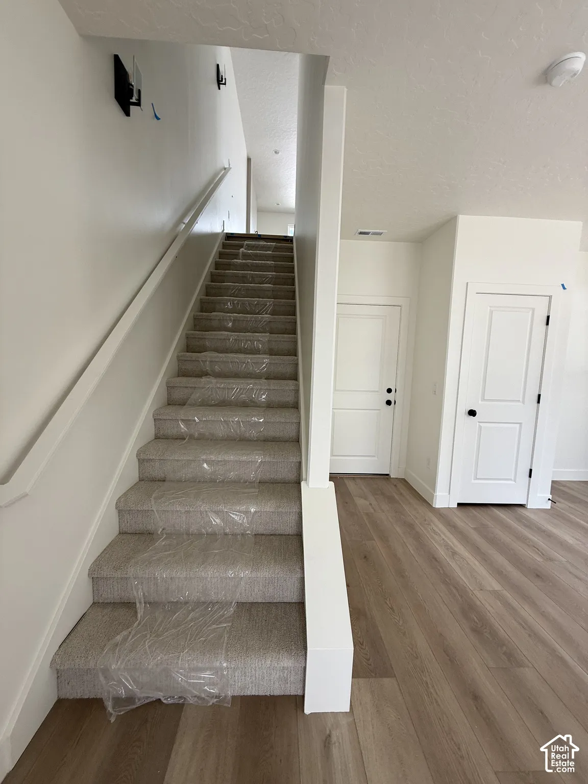 Staircase featuring carpeted treads and a painted handrail