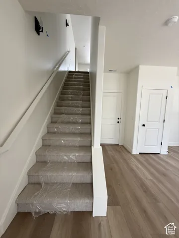 Staircase featuring carpeted treads and a painted handrail