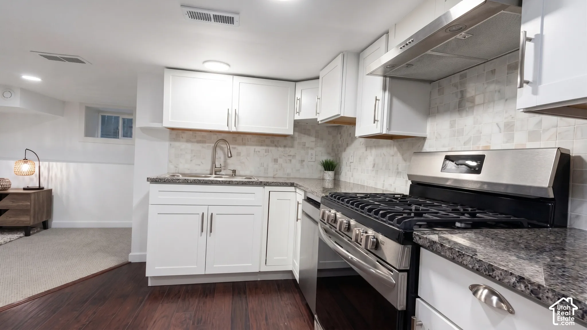 Second full kitchen features granite countertops, stainless steel appliances, and a tiled backsplash