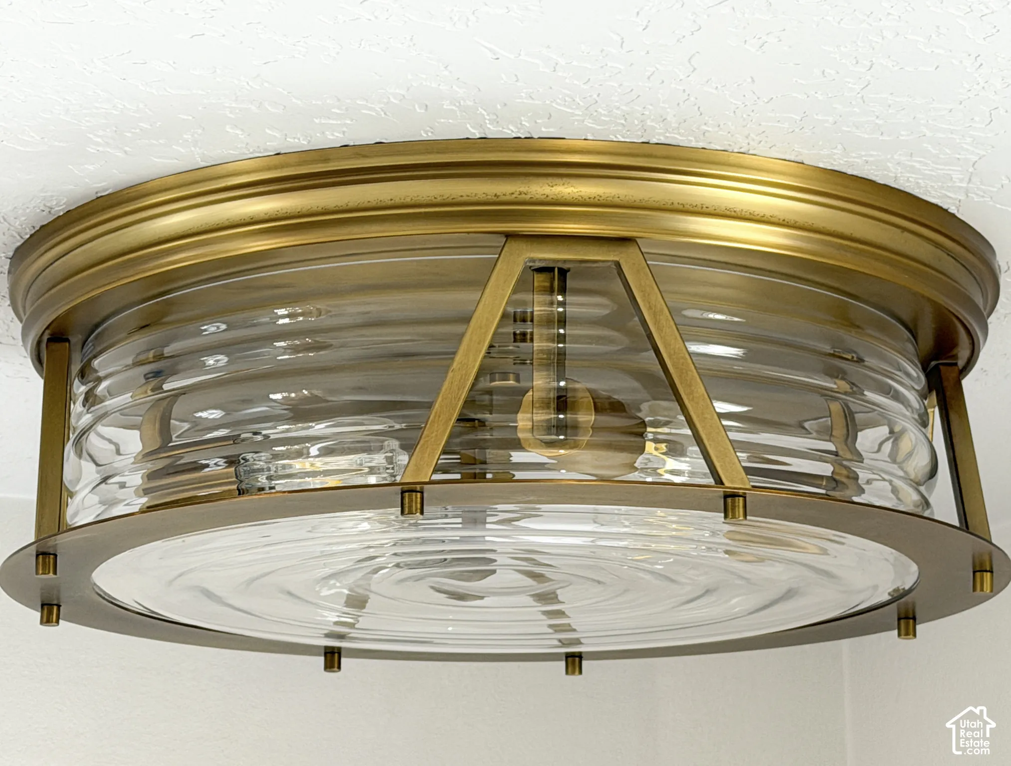 Brass-finish flush mount light fixture with clear ribbed glass and clear rippled glass base