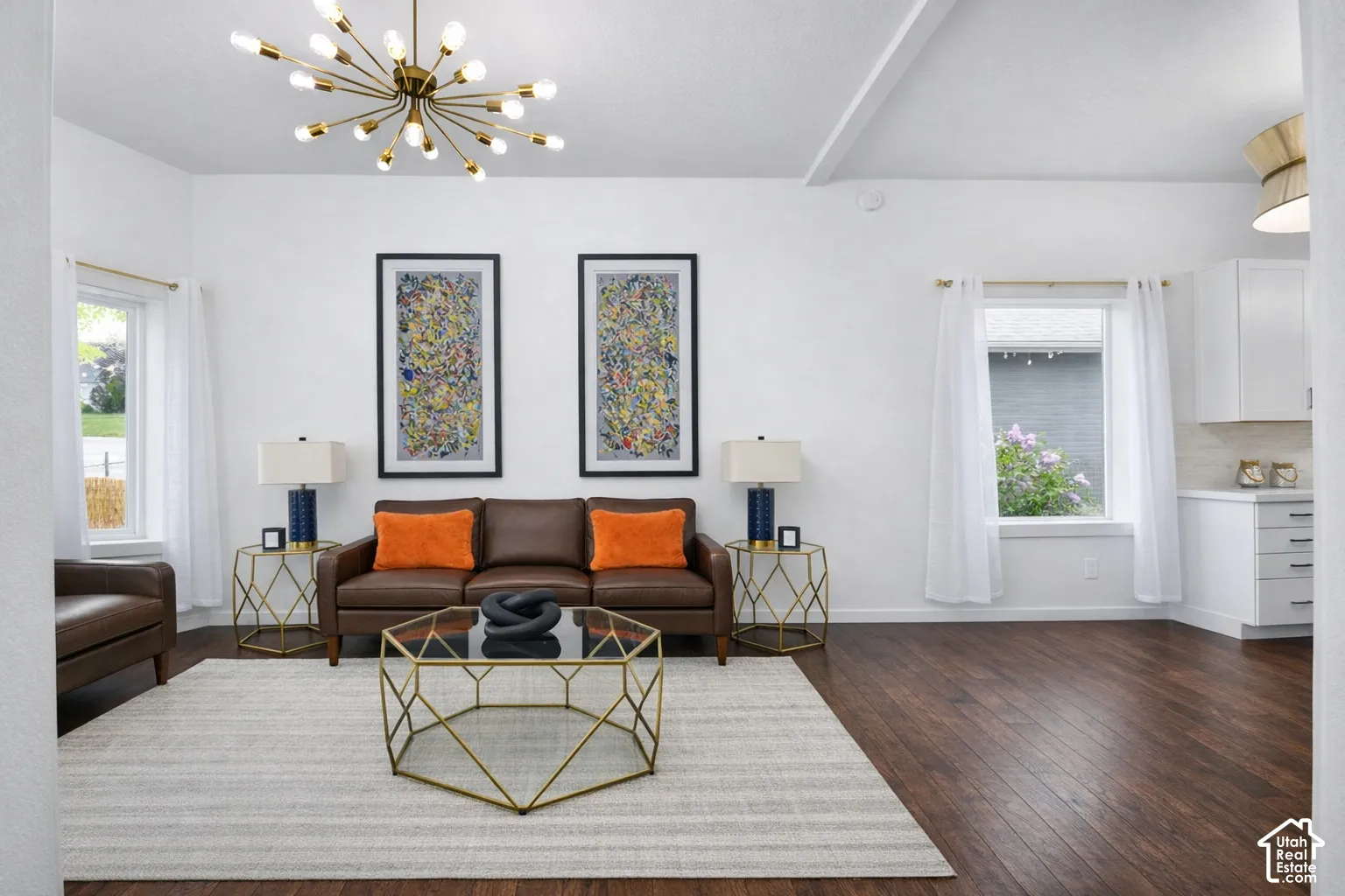 Hardwood-finish flooring, white walls, exposed ceiling beam, and a contemporary light fixture