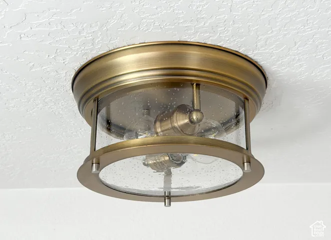 Ceiling-mounted fixture featuring an antique brass finish and clear seeded glass