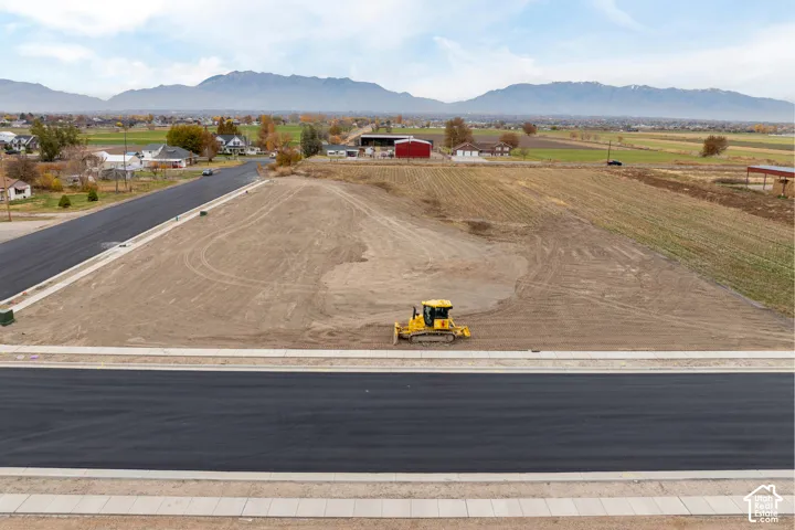 Cleared building lot with newly paved road and concrete curbing