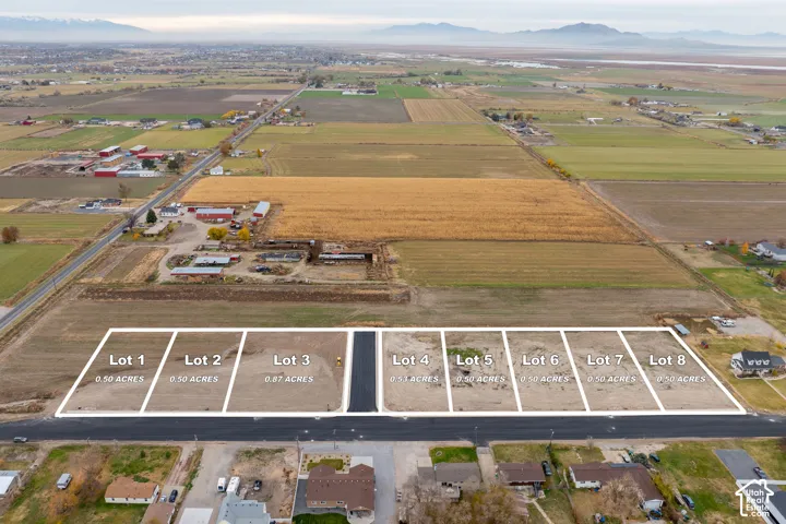 Multiple undeveloped parcels, visible road access, and mountainous backdrop