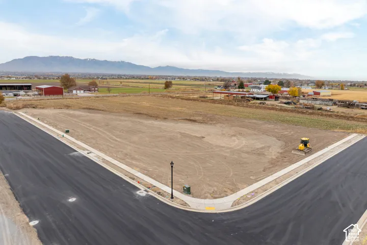 Corner lot with newly paved street, concrete sidewalk, and established street light