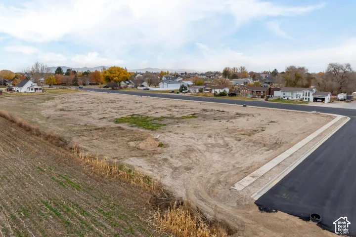 Expansive undeveloped lot with partial pavement and concrete curbing