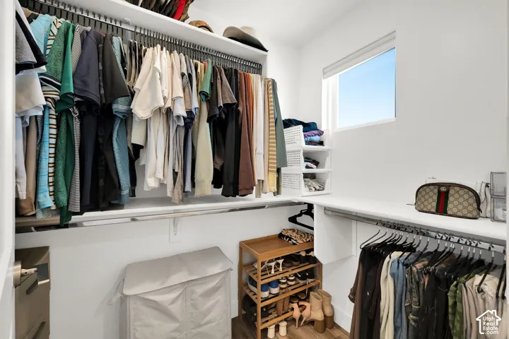 Custom closet system featuring multiple hanging rods, integrated shelving, and a privacy window