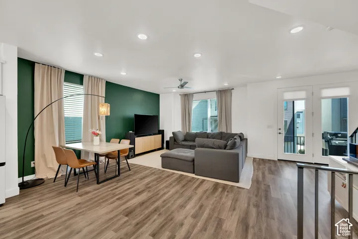 Wood-finish flooring, recessed lighting, ceiling fan, and large windows with blinds