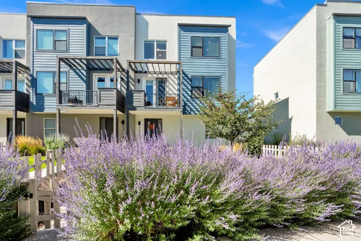 Multi-story residences featuring contemporary exterior finishes, balconies with metal railings, and integrated pergolas