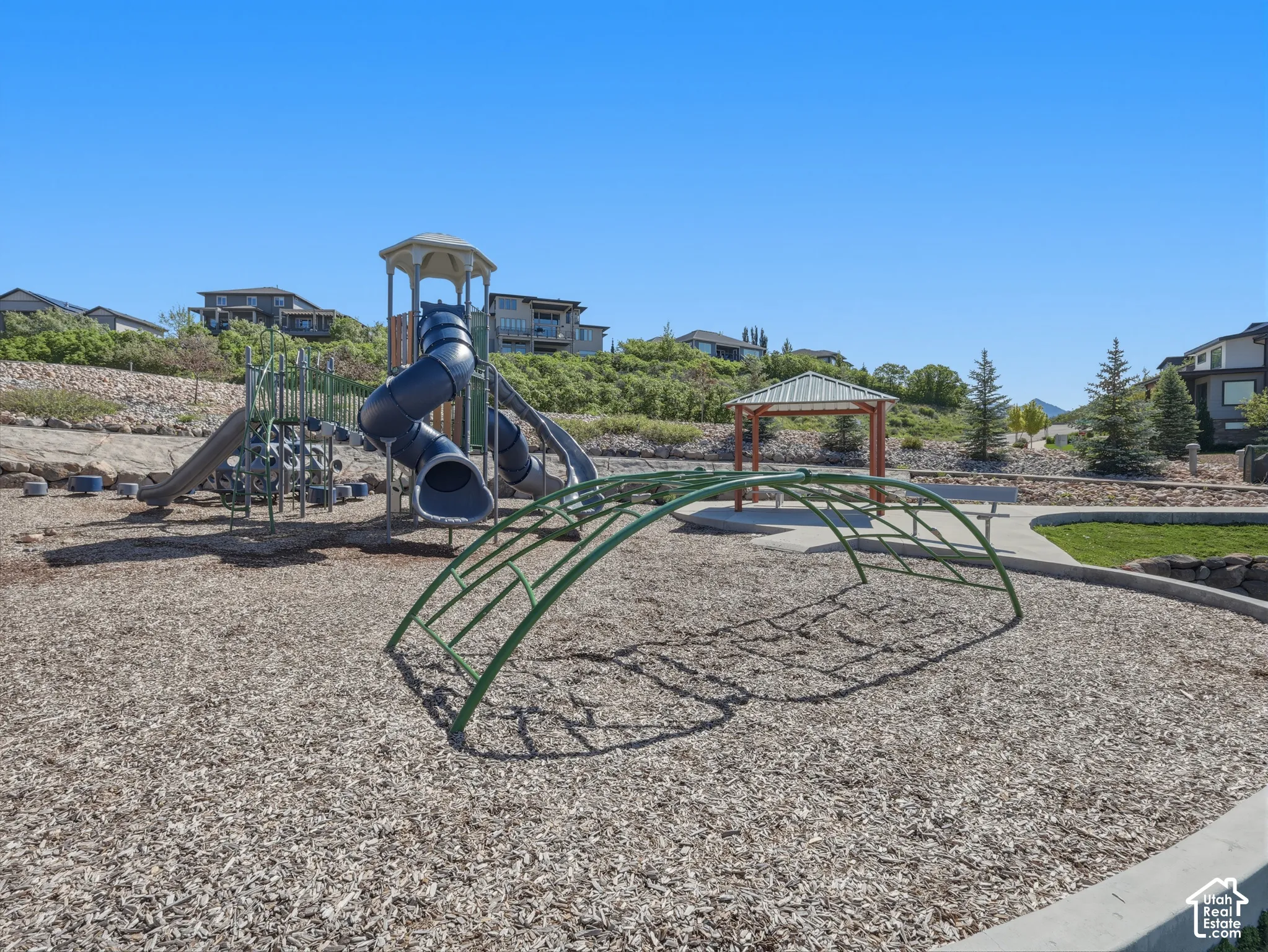 Community playground featuring multiple slides, climbing structures, and a shaded gazebo