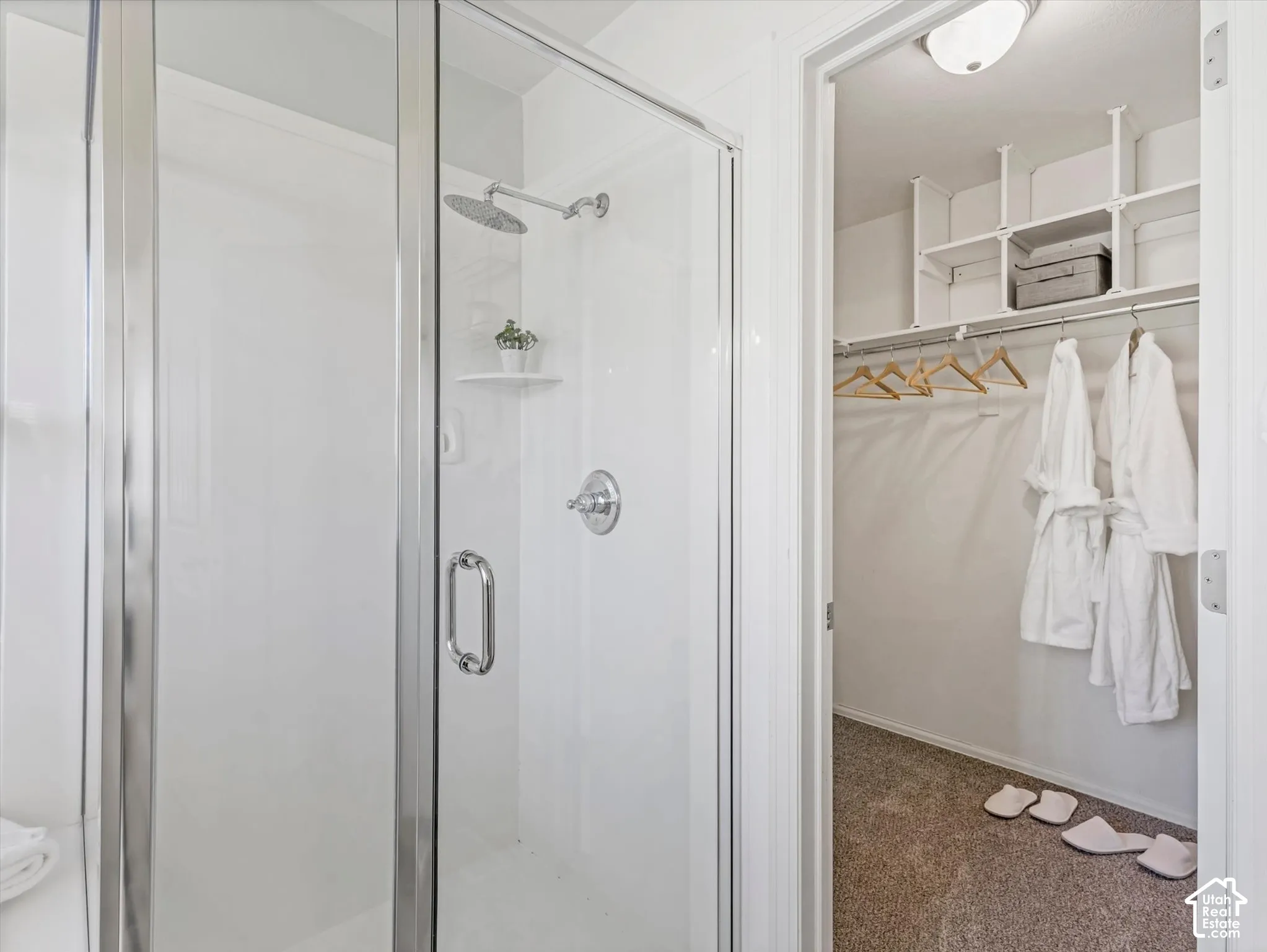 Walk-in shower with clear glass enclosure and chrome fixtures