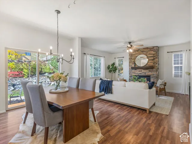 Wood-finish flooring throughout, a stone-clad fireplace with a wood mantel, and sliding glass doors