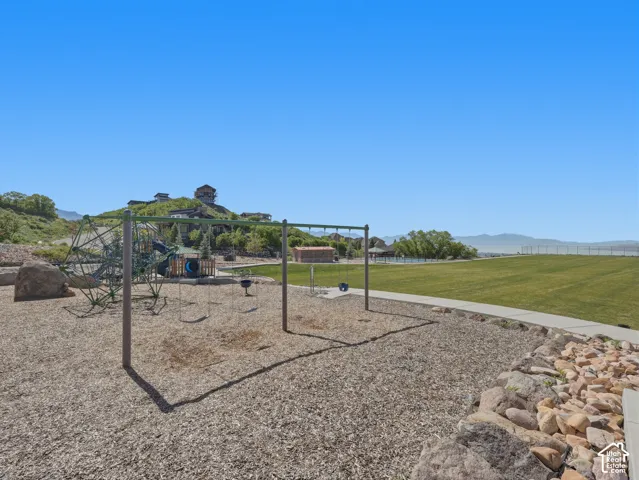 Playground area featuring swings, climbing structures, and a wood chip surface