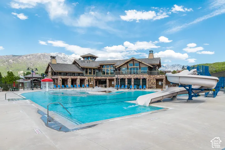 Expansive outdoor pool with integrated water slides and mushroom fountain feature