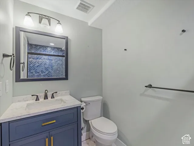 Modern vanity with a white rectangular sink, light-toned countertop, and matte black faucet