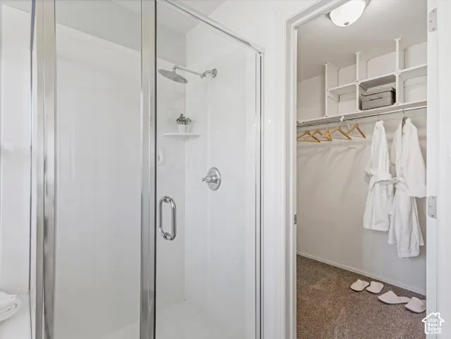 Walk-in shower with clear glass enclosure and chrome fixtures