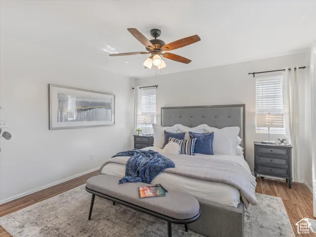 Wood-finish flooring with white walls and a ceiling fan