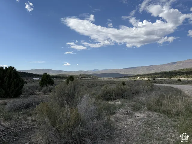 Expansive natural landscape with varied terrain and distant mountains under a clear sky