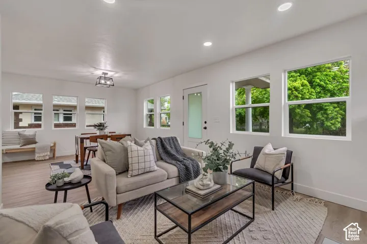 Open-concept living space featuring wood-finish flooring, recessed lighting, and multiple windows