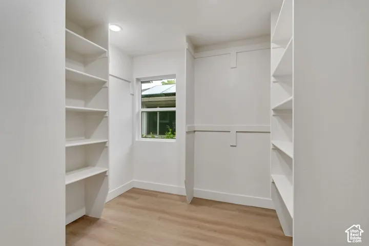 Built-in shelving, recessed lighting, wood-finish flooring, and a single window