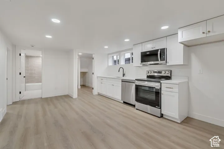 Modern kitchen featuring stainless steel appliances, white cabinetry with ample storage, and a sleek undermount sink