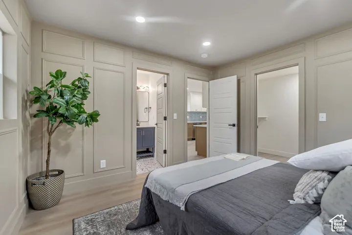 Decorative wall paneling, wood-finish flooring, recessed lighting, and a private closet with built-in shelving