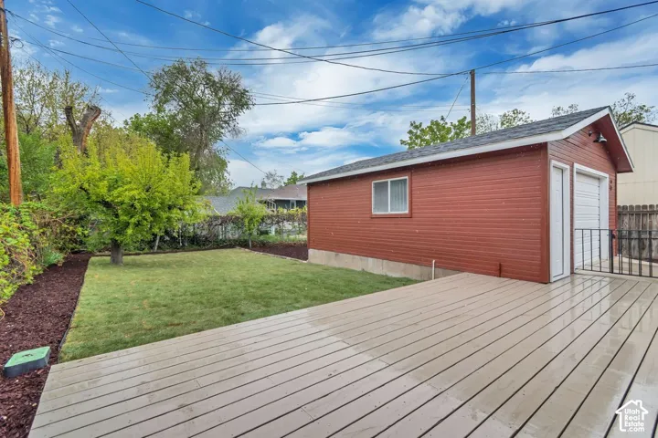 Exterior two-car garage with red siding, white trim, and a white roll-up door