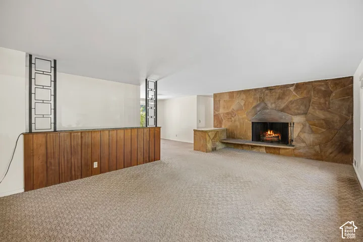Living room with stone accent wall featuring a wood-burning fireplace