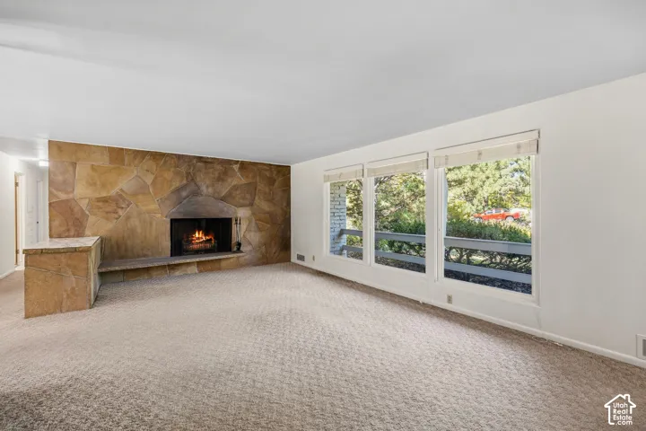 Living room with stone accent wall featuring a wood-burning fireplace