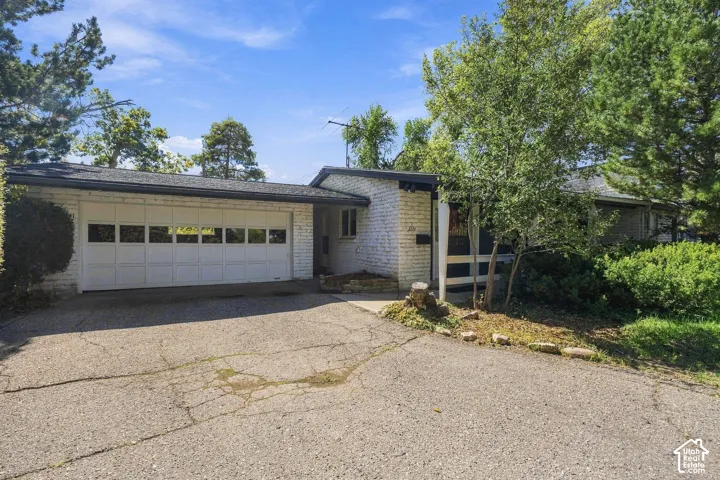 Front exterior with masonry facade, attached two-car garage, and asphalt driveway
