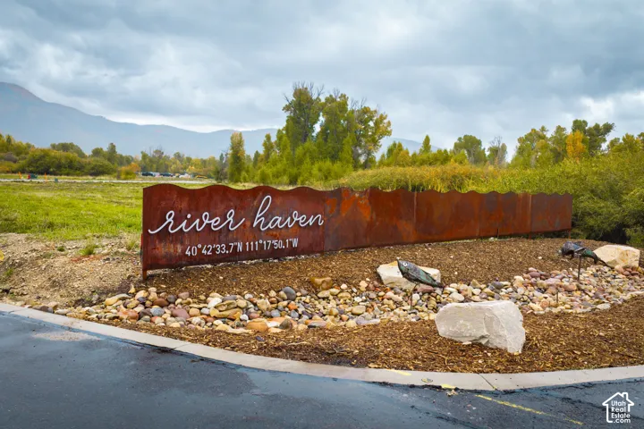Cor-Ten steel signage with integrated lettering, set within a landscaped bed featuring river rock and natural stone elements