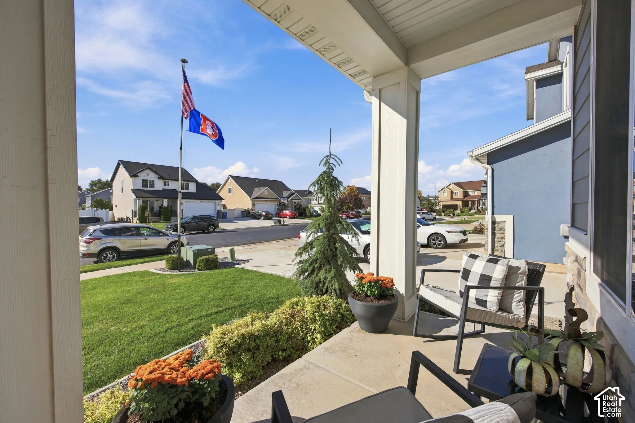 Front porch with a concrete surface, white columns, and a blue exterior
