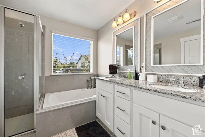 Dual vanity with granite countertops, undermount sinks, and white shaker-style cabinetry