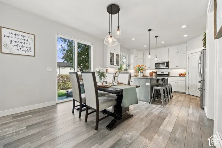 Wood-finish flooring throughout, with a white kitchen featuring stainless steel appliances and a dark-toned island