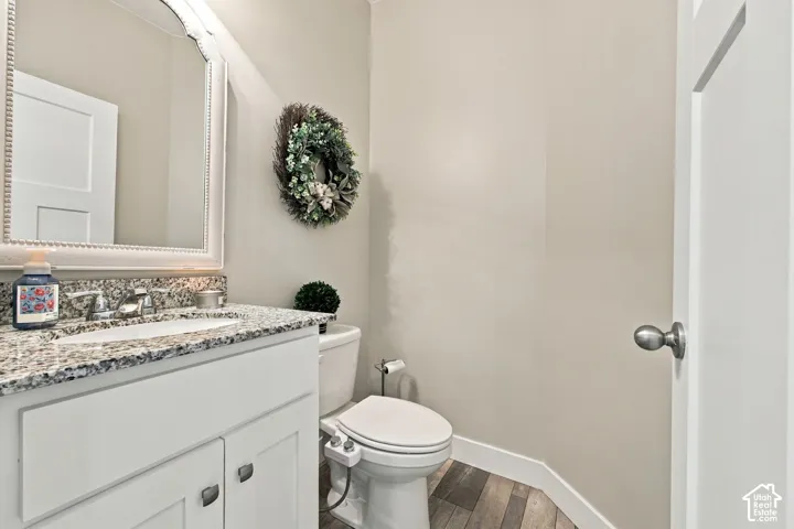 White vanity with granite countertop, undermount sink, and chrome fixtures