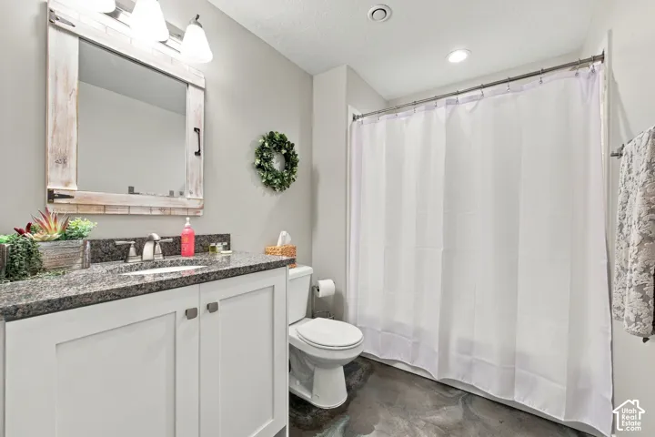Vanity with a granite countertop, white cabinetry, and brushed nickel hardware