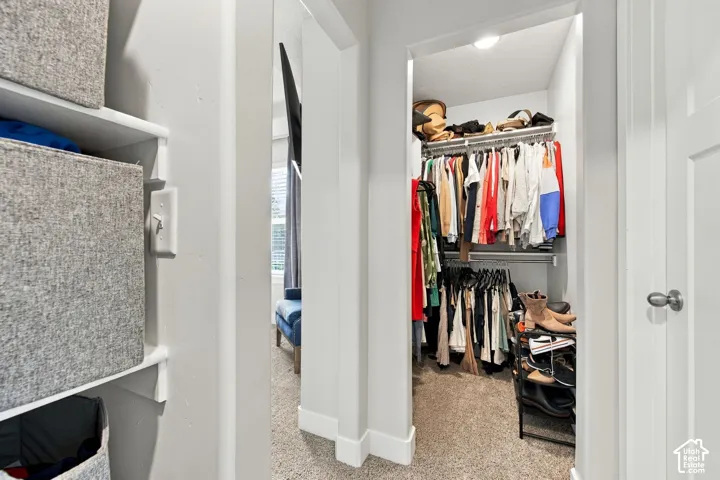 Walk-in closet with built-in shelving, hanging rods, and recessed lighting