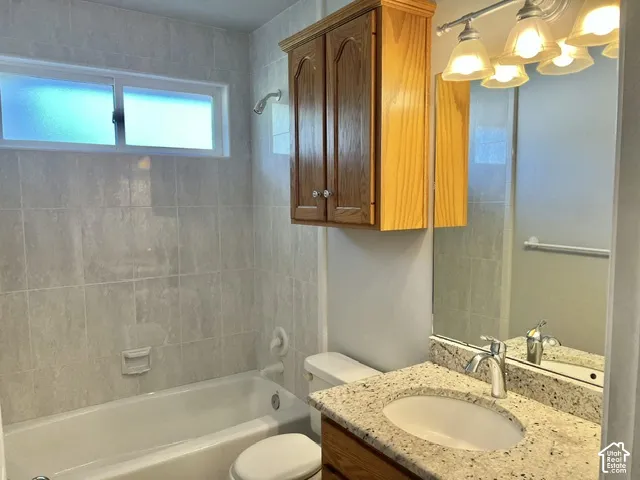 Bathroom featuring a vanity with a white undermount sink, speckled countertop, and chrome faucet