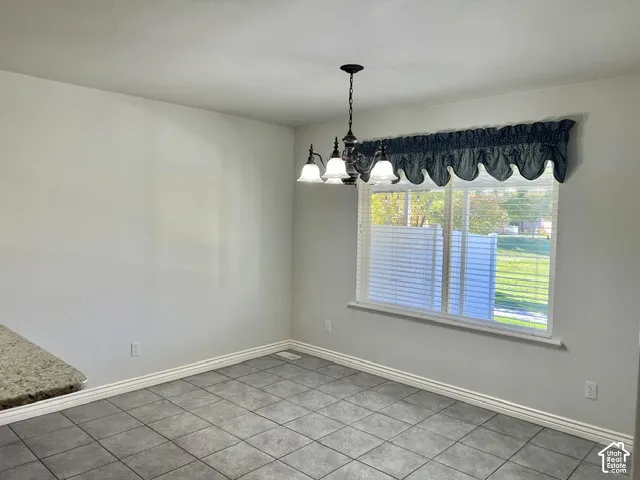 Recessed lighting, tile flooring, window with blinds, a multi-light chandelier, and a granite-finish countertop