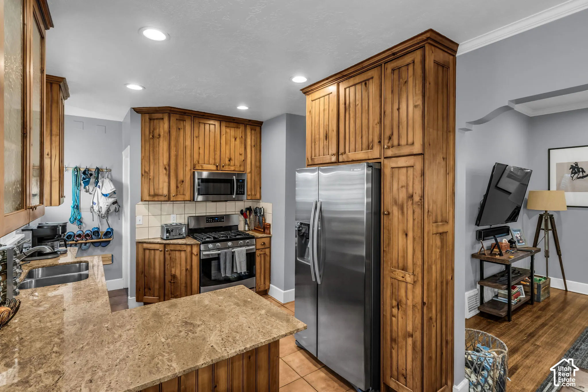 Wood cabinetry with stainless steel appliances, recessed lighting, and a durable countertop