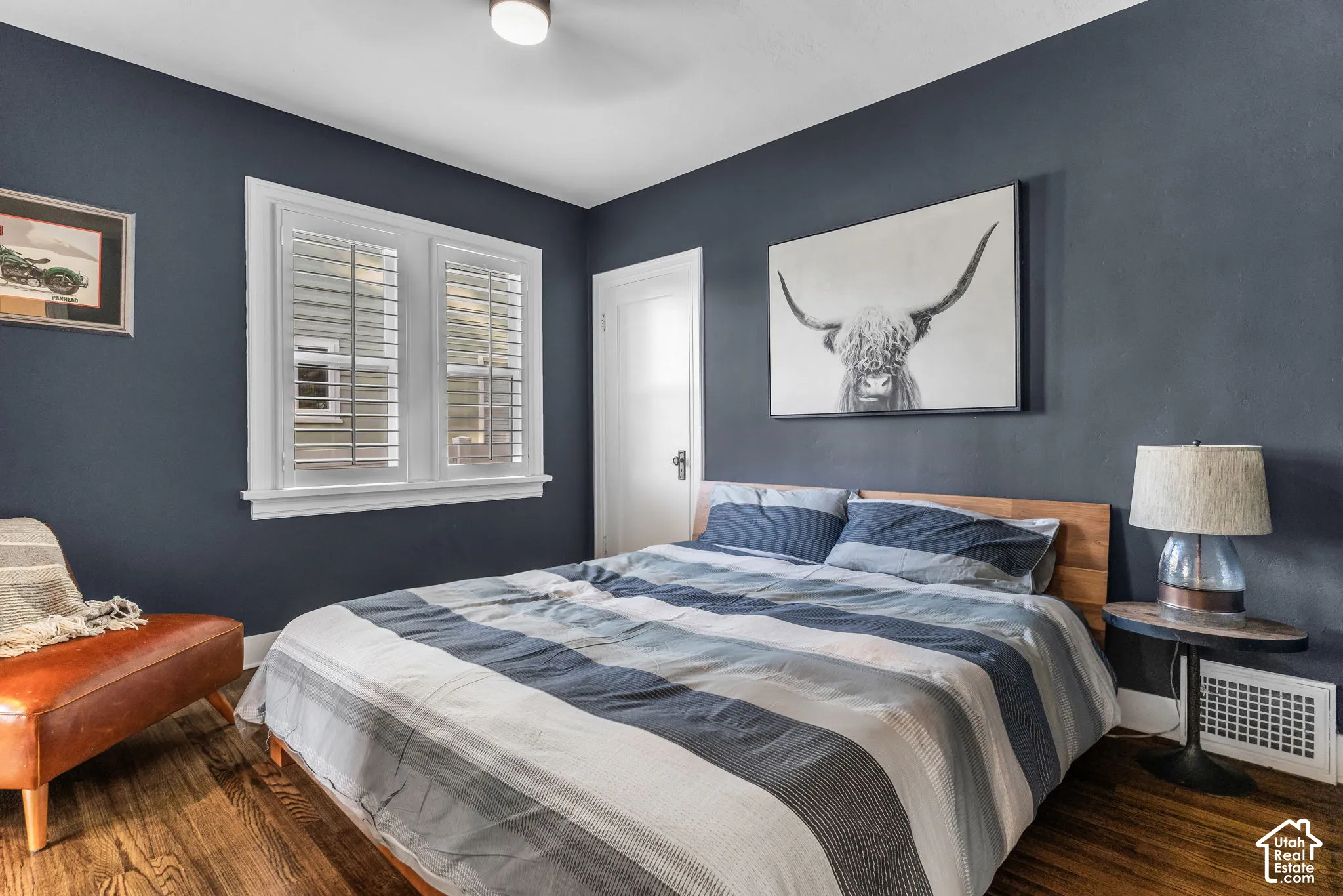 Richly colored walls, wood-finish flooring, white window trim, and a ceiling-mounted light fixture